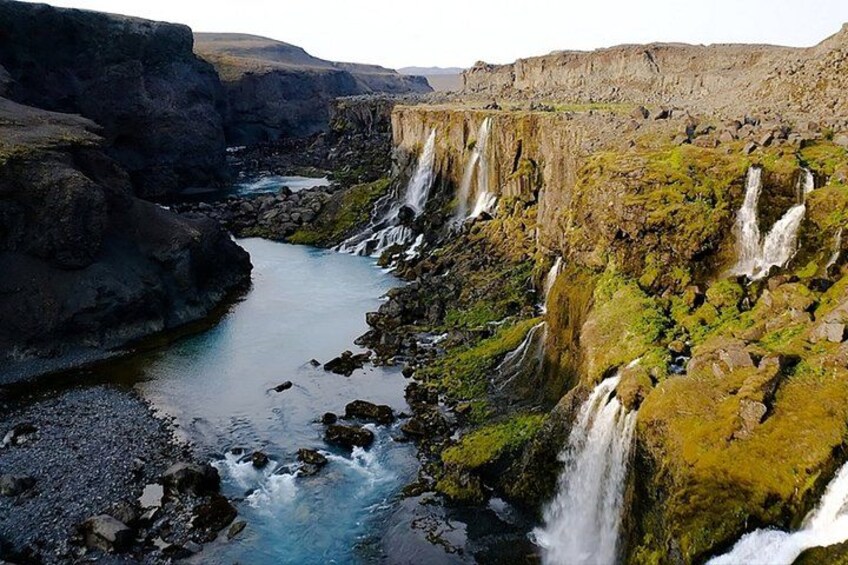 A river flowing through a rocky canyon with multiple waterfalls. 2