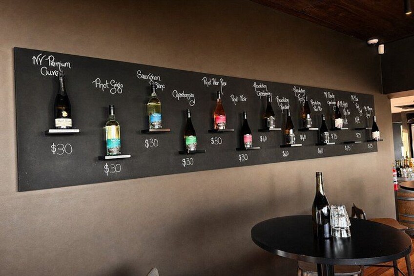 A wine tasting menu with various wines and their prices on a blackboard. 5