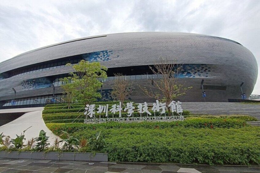 A modern building with a curved facade and a sign in a foreign language. 2