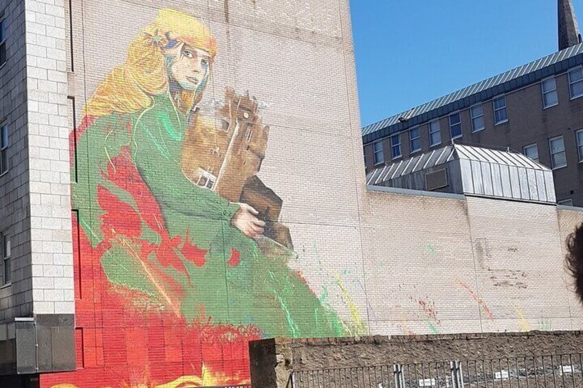 A large mural on a building featuring a person holding a horse. 4