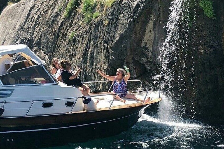 A boat with people enjoying a waterfall. 2