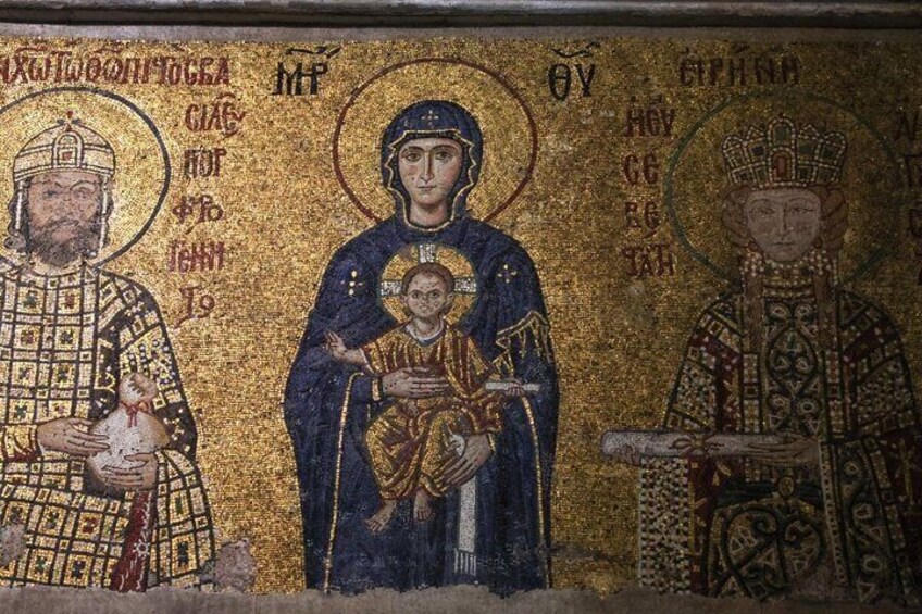 A mosaic with three figures, one holding a child, surrounded by ornate patterns and inscriptions. 3
