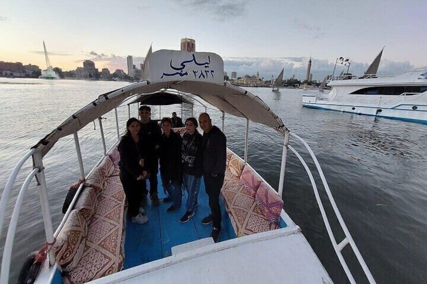 A group of people on a boat with a city skyline and sailboats in the background. 5