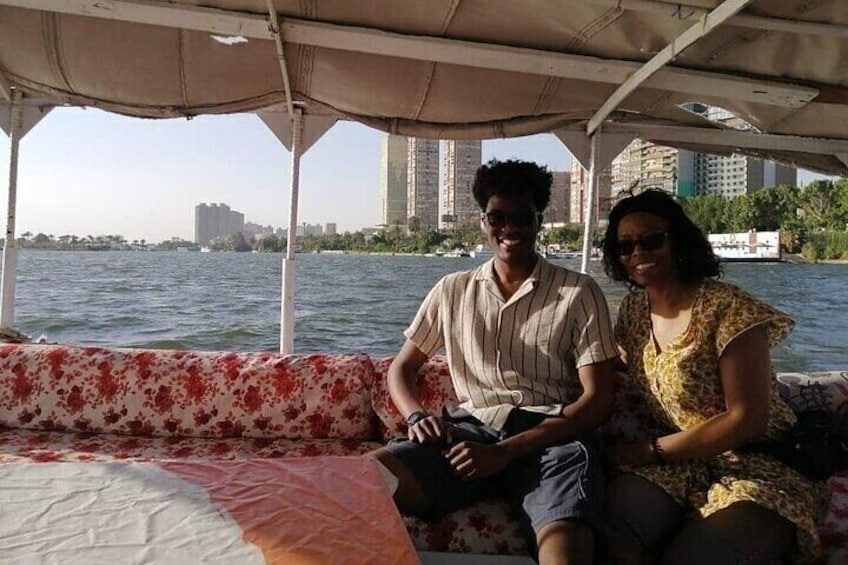 Two people on a boat with a cityscape in the background. 4