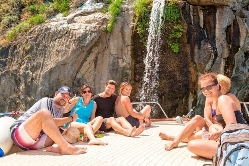 Un gruppo di persone sedute su un pontile di legno vicino a una cascata. 2