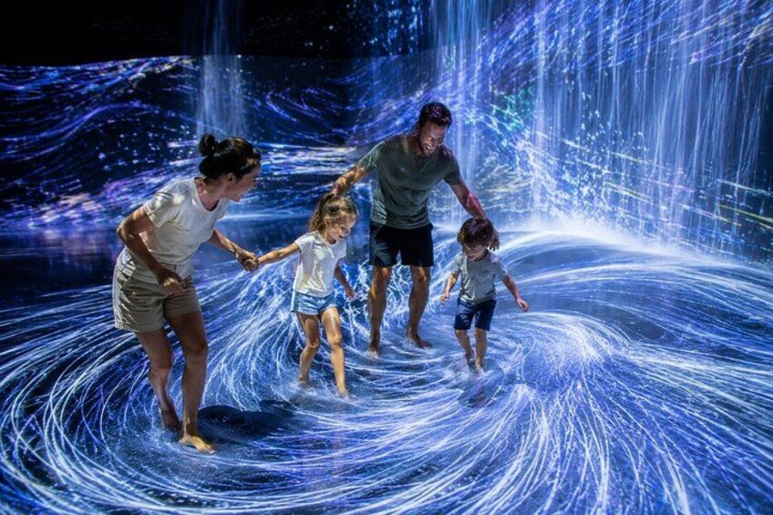 A family enjoying a water feature with dynamic light effects. 2