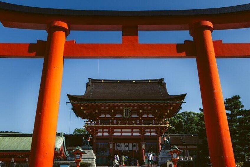 Ein traditionelles japanisches Gebäude mit einem roten Torii-Tor im Vordergrund. 5