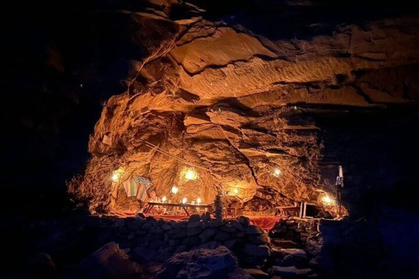 A cave illuminated with lights, with a small structure inside. 1