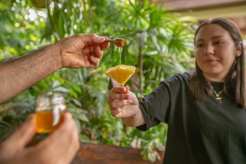 En person häller honung i ett cocktailglas. 5