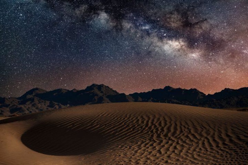 Un paysage désertique avec des dunes de sable sous un ciel étoilé. 3