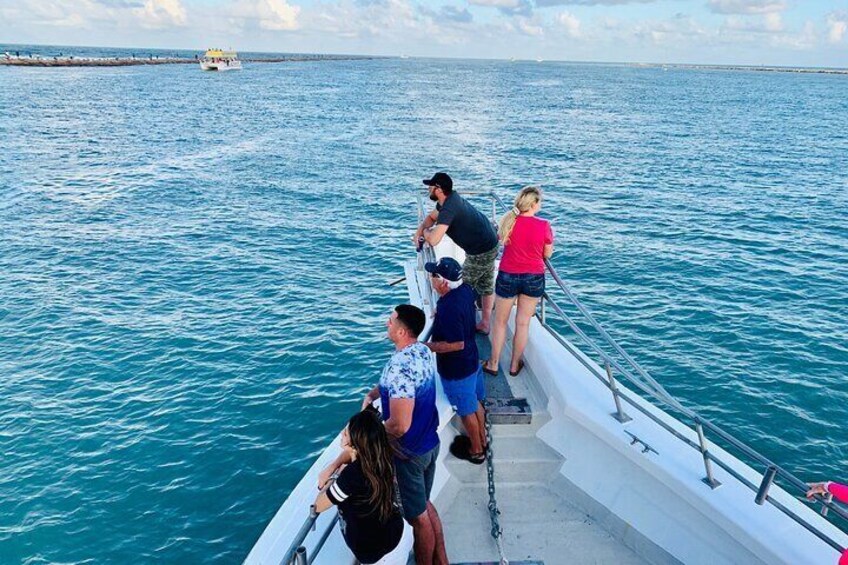 A group of people on a boat with a pier in the background. 5