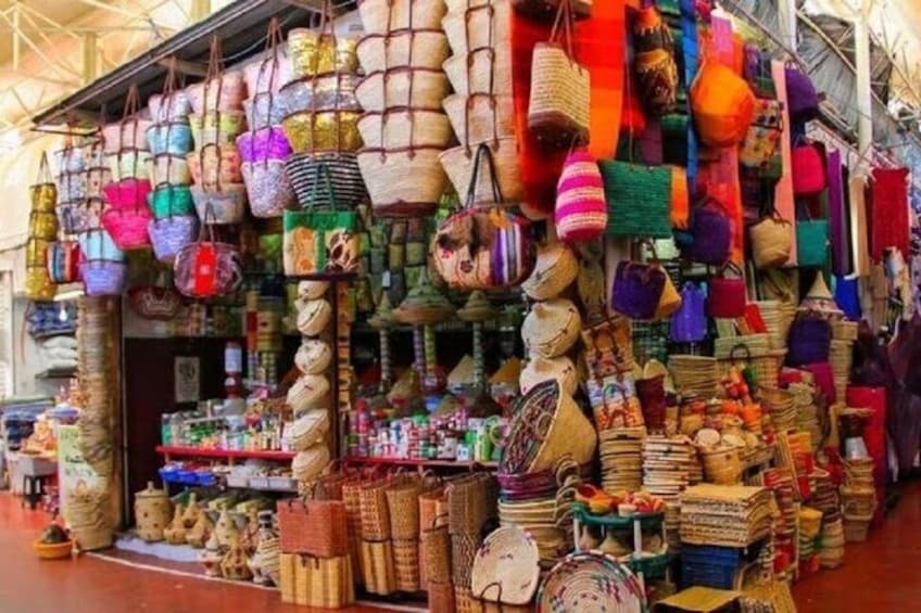 Una bancarella di mercato con diversi sacchi e cesti intrecciati. 2