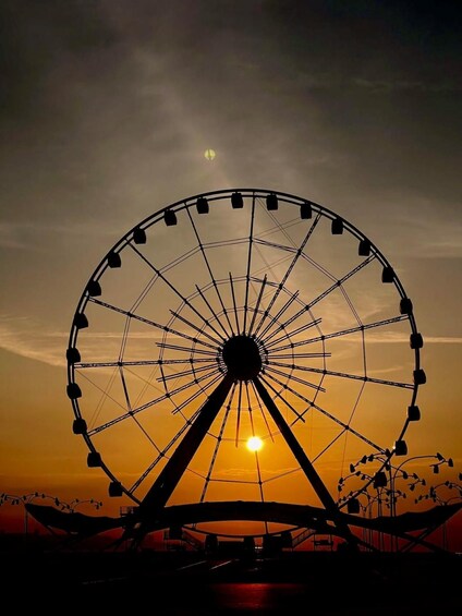 Una noria grande recortada contra un cielo al atardecer. 5