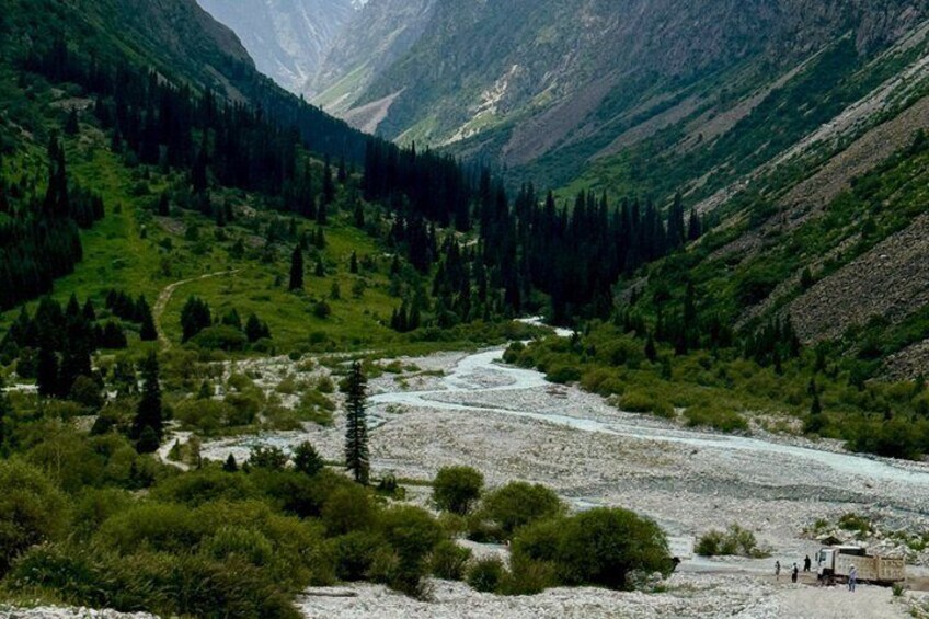 A river winding through a mountainous landscape with dense forests and rocky terrain. 5