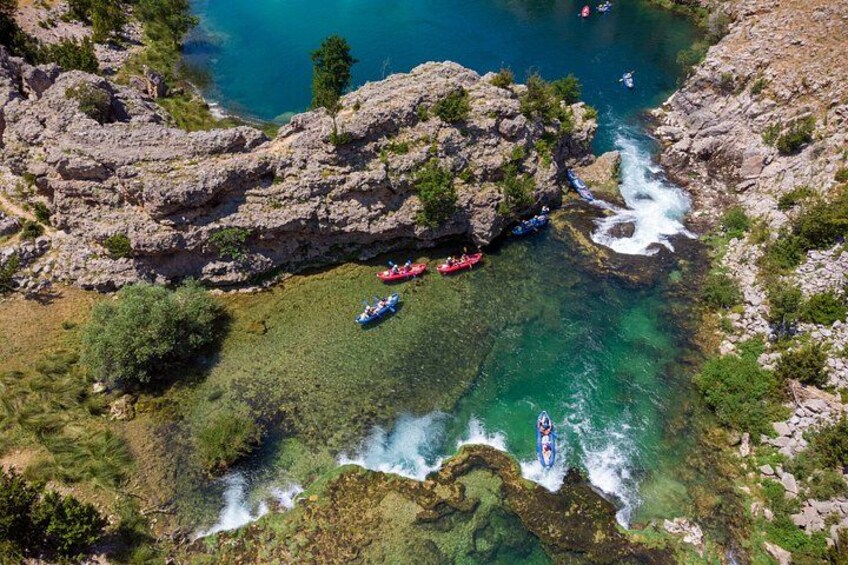 Un río con barcos, terreno rocoso y agua cristalina. 4