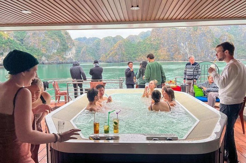 Un jacuzzi sur un bateau, où des personnes se détendent et profitent de la vue sur un lac entouré de collines. 4