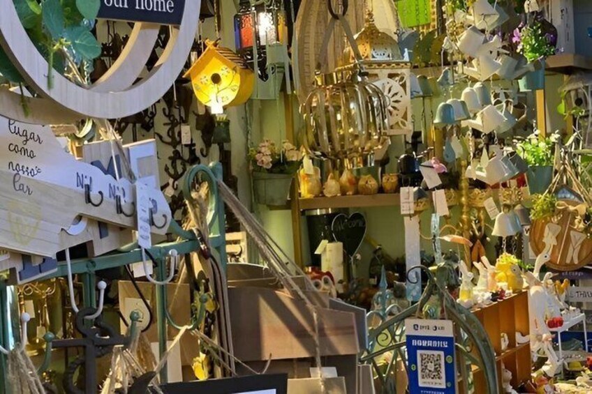 Un mercato al chiuso affollato, pieno di oggetti vari come lampade, pentole e decorazioni appese. 3