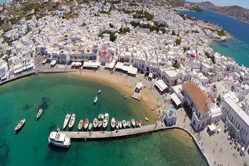 A coastal town with white buildings, a pier, and boats. 2