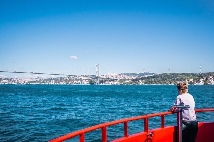 Eine Person in einem Boot, eine Brücke und eine Stadtlandschaft im Hintergrund. 4