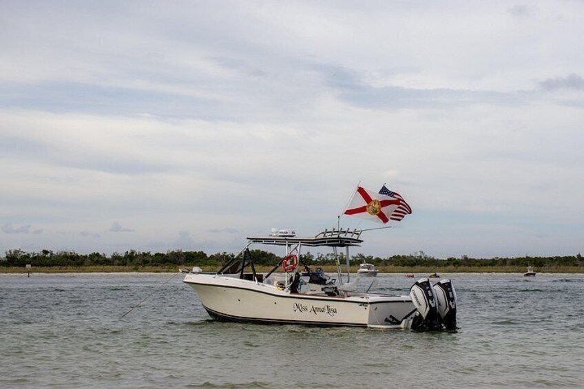 A boat named 'Miss Annita Rosa' on calm water with a flag flying. 1