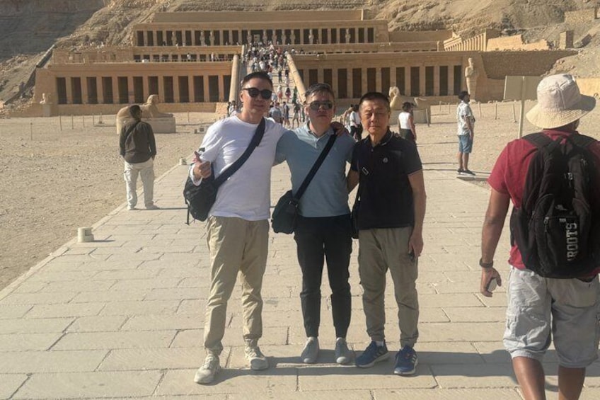 Un groupe de personnes se tient devant un ancien temple égyptien, devant lequel s’élève un grand escalier. 4