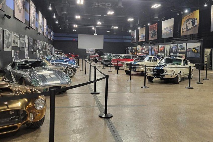 A car museum with various classic cars on display. 2