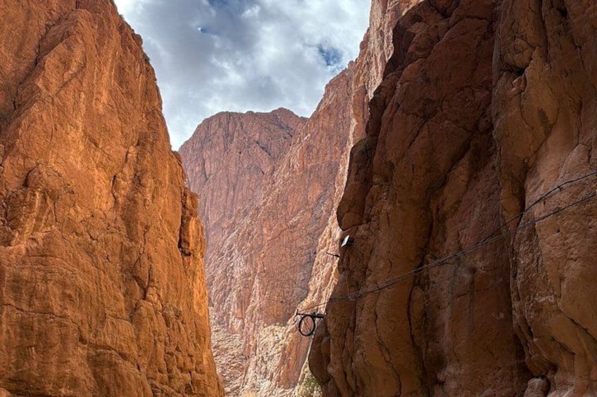 A canyon with red rock walls and a barbed wire fence. 4