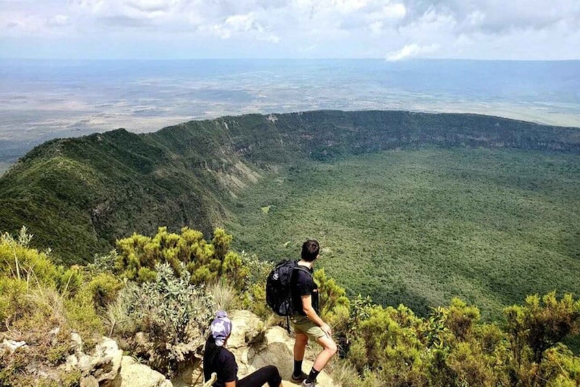 A hiker on a mountain trail with a view of a valley. 4
