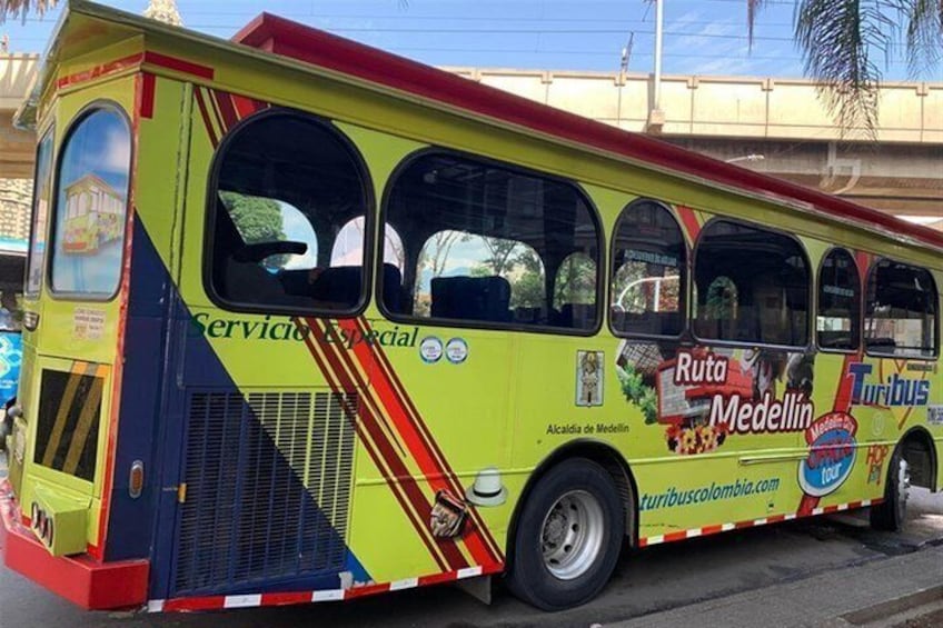 En farverig bus med reklamer for Ruta Medellín og Tribus. 2