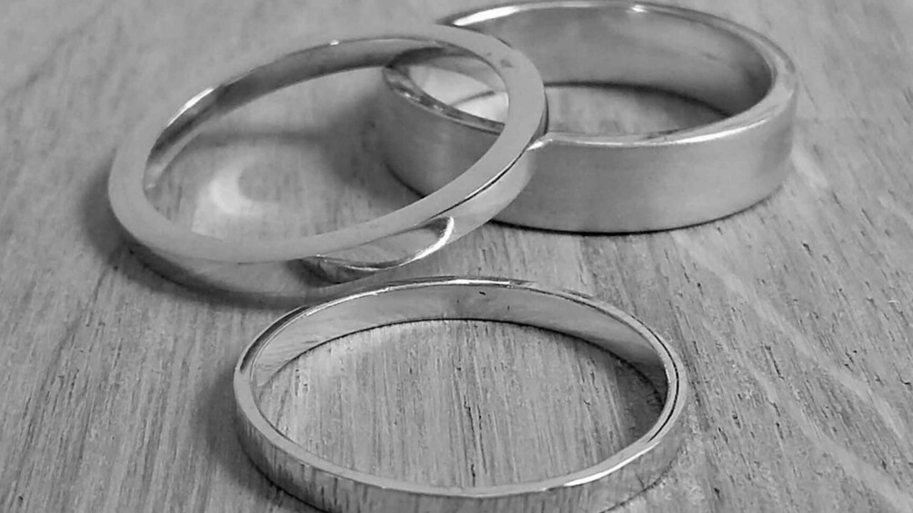 Three metallic rings on a wooden surface. 1