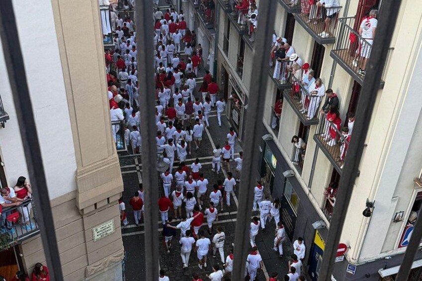 Une rue bondée, où l’on aperçoit des gens vêtus de blanc et de rouge, probablement pour un défilé ou un événement. 5