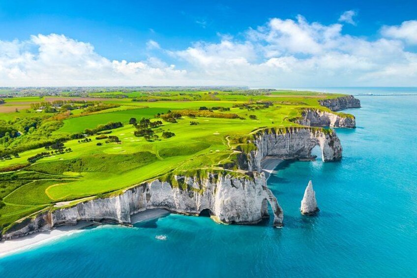 Eine Küstenlandschaft mit Klippen, einem Golfplatz und einem klaren, blauen Meer. 1