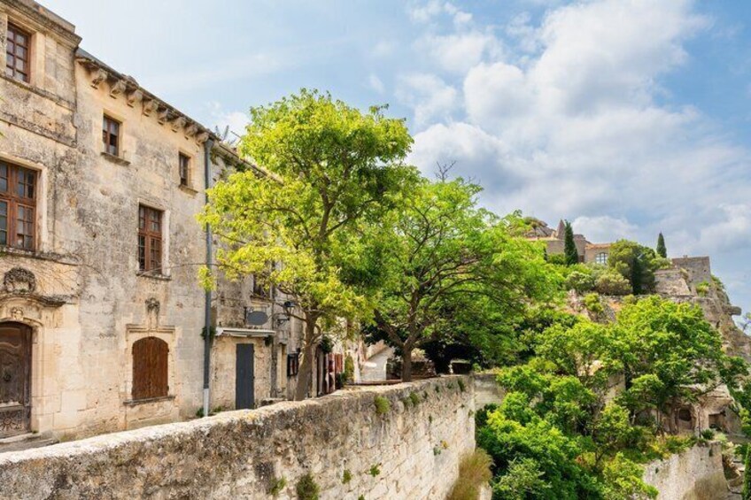 Un puente de piedra, edificios históricos y abundante vegetación. 2