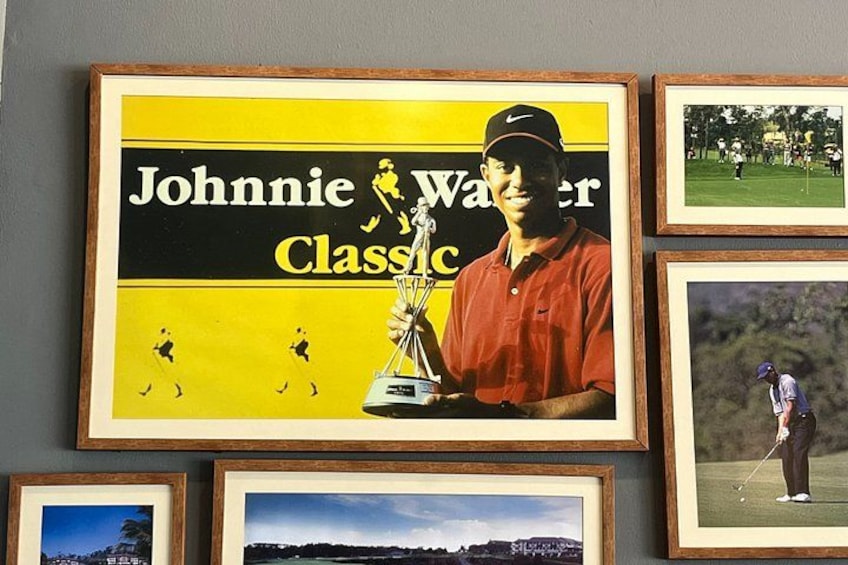 A framed golf-related poster with a golfer holding a trophy. 4