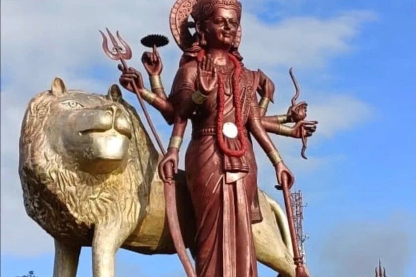 Una estatua de una deidad con un león, sobre un cielo despejado. 5