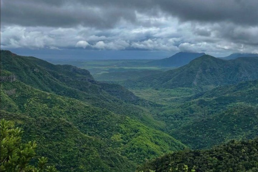 Un paisaje montañoso con abundante vegetación y un valle. 4