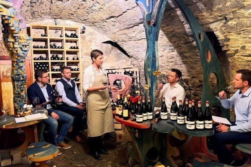 A wine cellar with bottles on shelves and a tasting area. 1