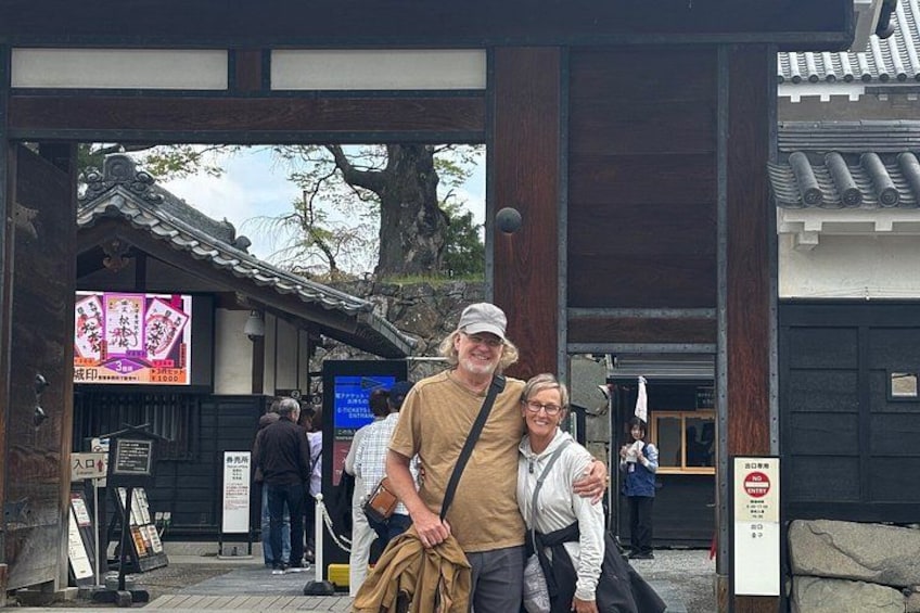 A traditional Japanese gate with people standing in front. 3