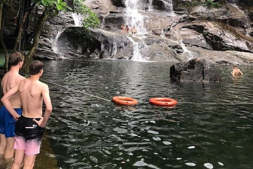 A waterfall, rocky terrain, and people in a natural setting. 2