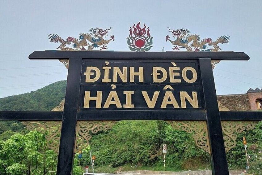 A sign with the text 'Dinh Deo Hai Van' and decorative dragon motifs. 4