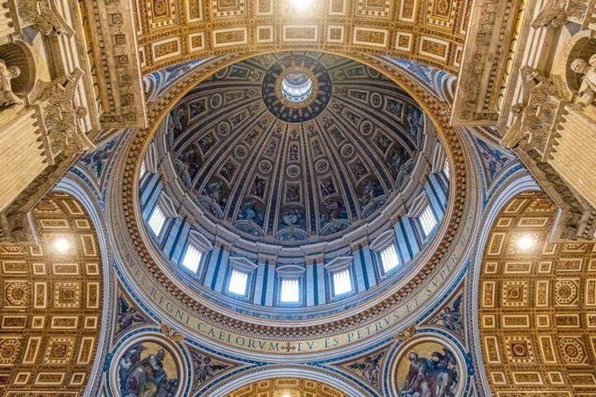 A grand architectural dome with intricate carvings and inscriptions, featuring a central circular design and multiple windows. 1