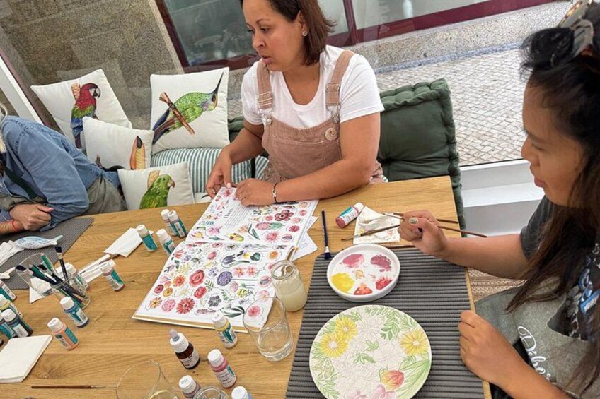 A group of people painting on a table with various art supplies. 3