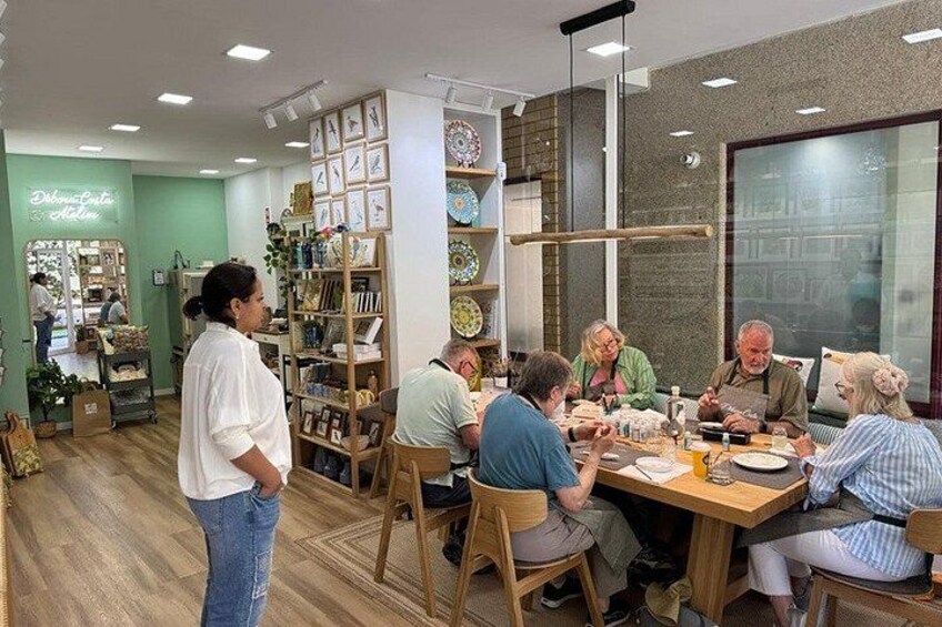 A group of people dining at a wooden table in a cafe with shelves of books and decorative items in the background. 4