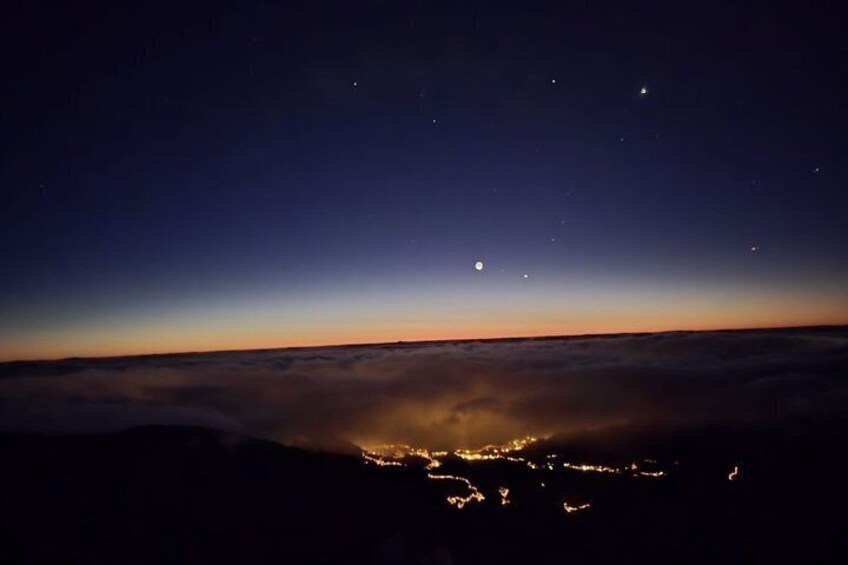 A night sky over a city with visible stars and a crescent moon. 4