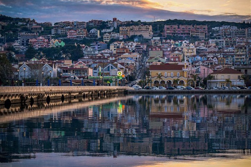 A waterfront cityscape with a bridge, buildings, and a reflection in the water. 4