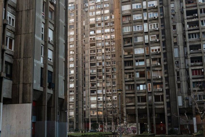 Een hoog, meerijig gebouw met veel ramen en balkons. 1