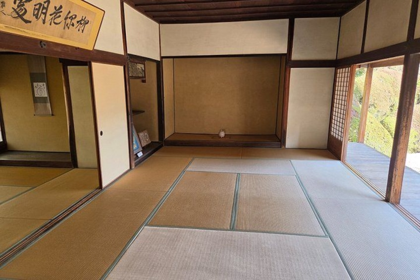 A traditional Japanese room with tatami flooring, sliding doors, and a wooden beam ceiling. 3