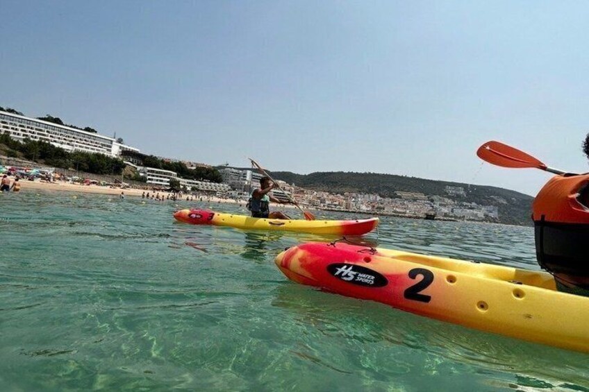 Une plage avec des kayaks et une personne qui rame. 2