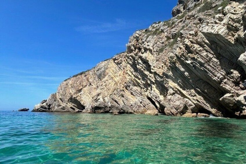 Une côte rocheuse bordée d’une eau turquoise et cristalline. 4