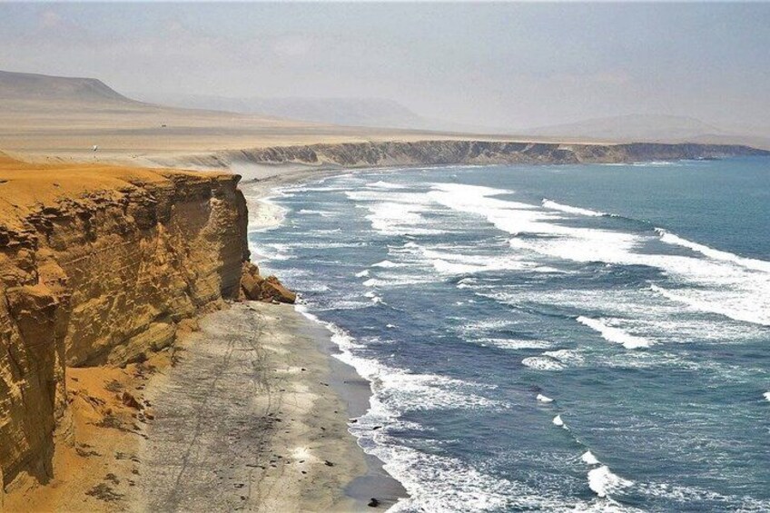 A coastal cliff with waves crashing against it. 3